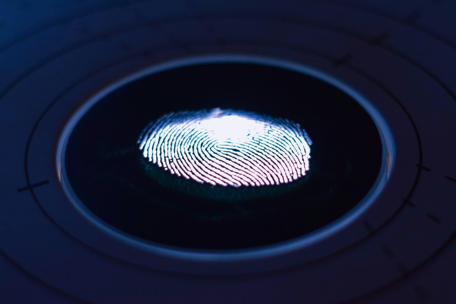 Huella dactilar iluminada sobre un lector biométrico